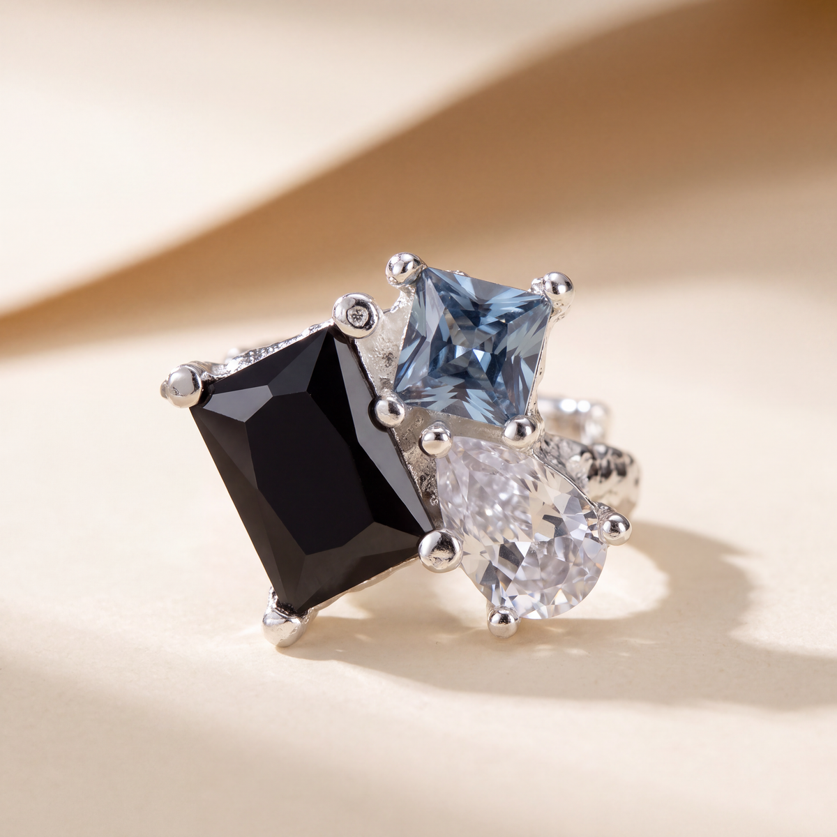 Side view of the silver Dewdrop Ear Cuff showing the pear-cut blue stone and open cuff band