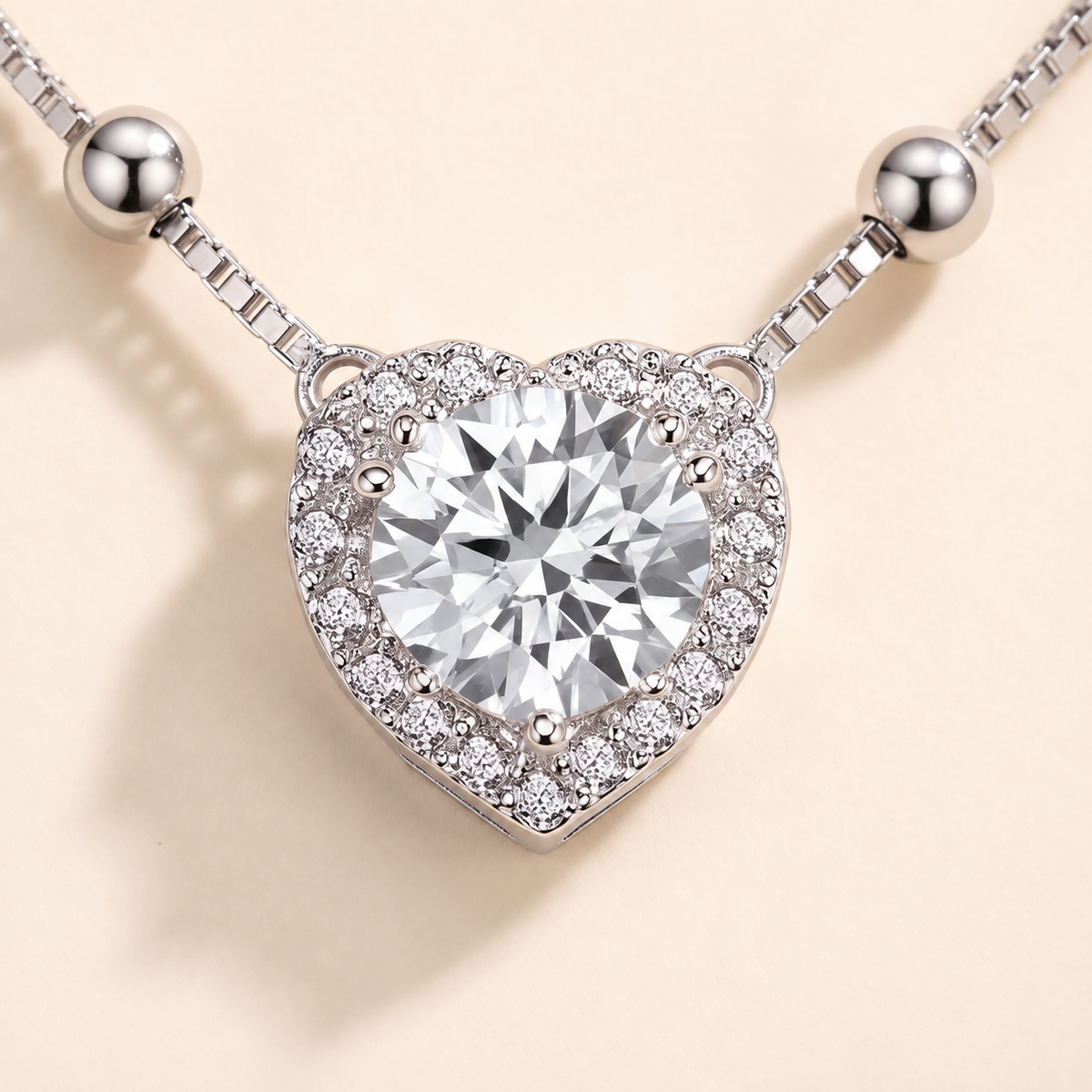 Macro view of the heart cut moissanite in a four prong setting with a halo of small moissanite stones, Juliet necklace by Kavati