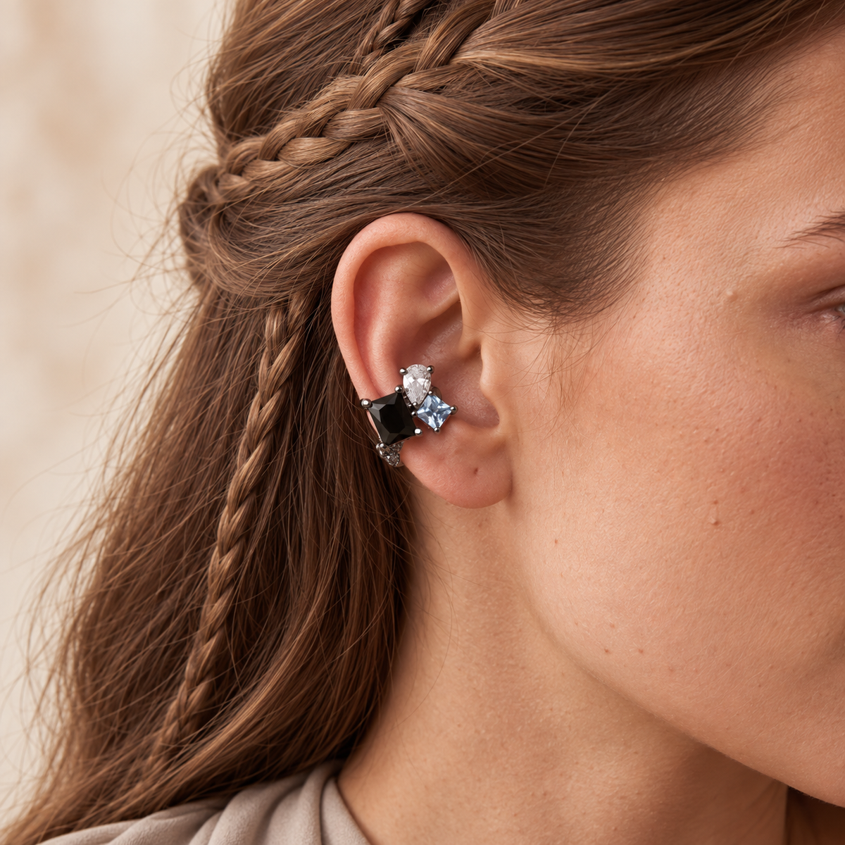 Dewdrop Ear Cuff in polished silver with a blue pear-cut cubic zirconia, worn on the upper ear