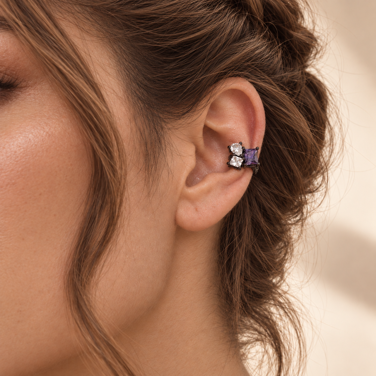 Dewdrop Ear Cuff in blackened silver with a purple pear-cut cubic zirconia, worn on the upper ear