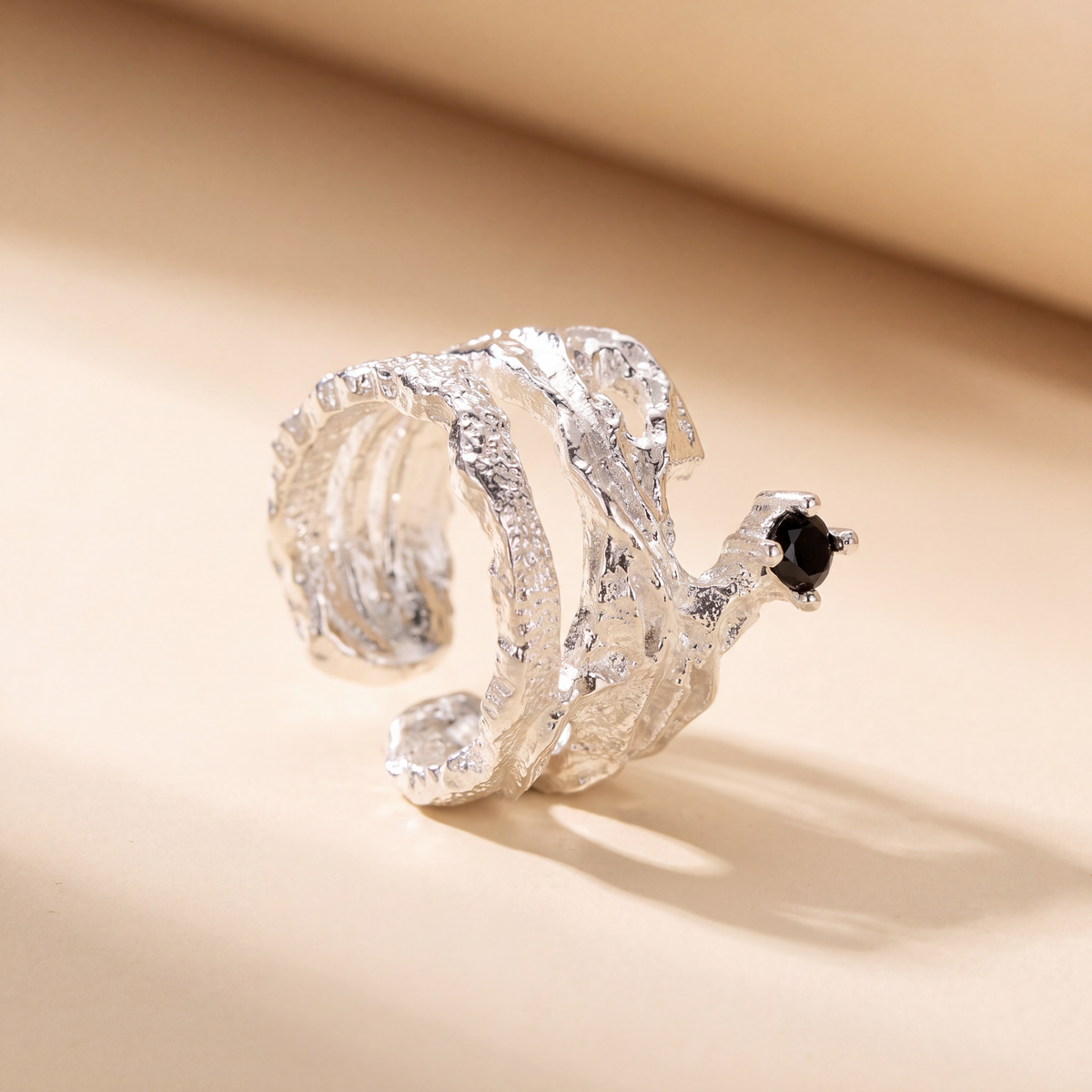 Close view of the Meteorite Ear Cuff showing the rough molten silver texture around the black cubic zirconia