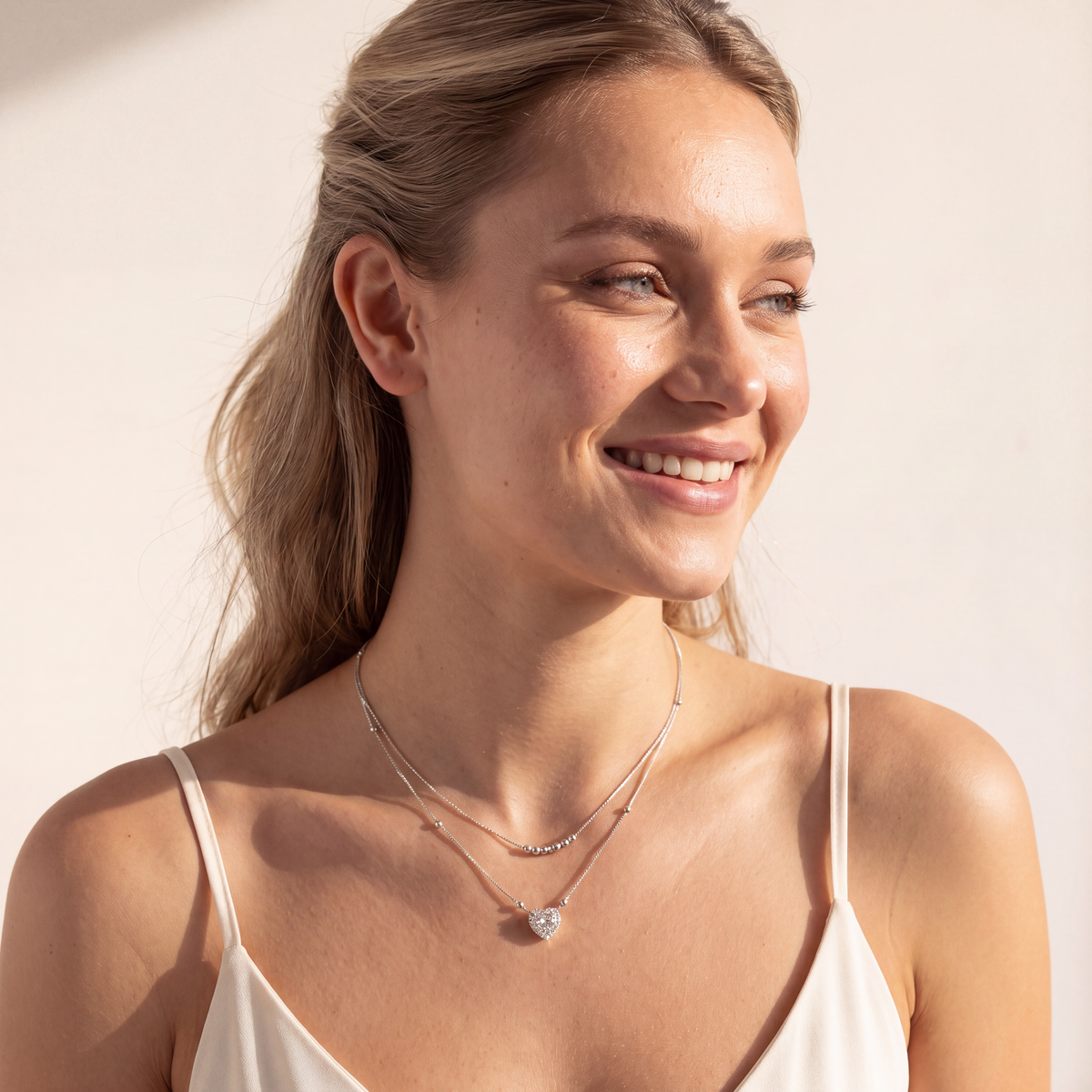 Model wearing the Juliet layered moissanite heart necklace, front view showing both silver chains and heart pendant