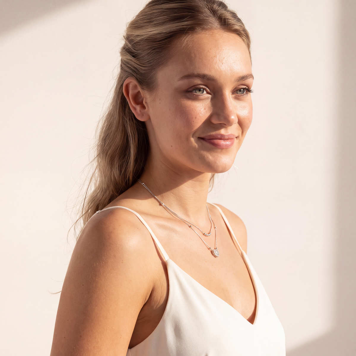 Model in side profile wearing the Juliet double chain moissanite heart necklace in sterling silver